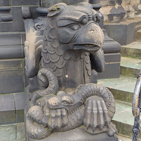A griffon sculpture, his face looking as if he was saying 