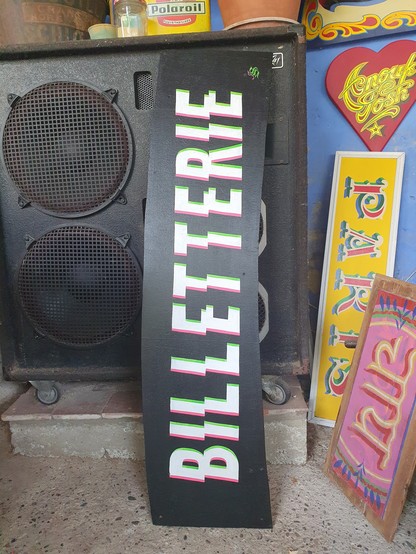 Billetterie ticket sale sign with jagged lettering leaning against a large speaker cab
