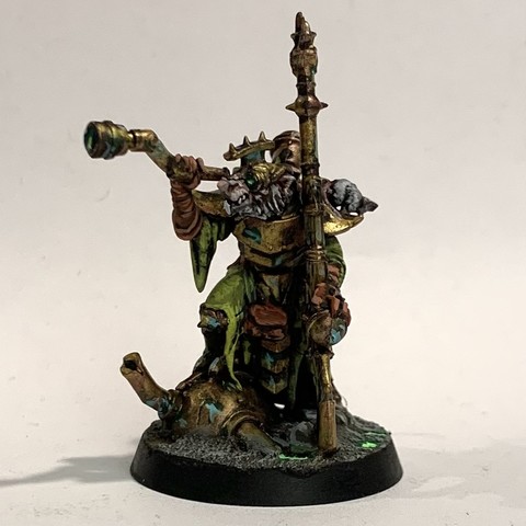 A Skaven Warlock Engineer rat-man. He has a telescope up to his eye. He carries a long rifle and wears green-yellow robes and tarnished bronze armor. 