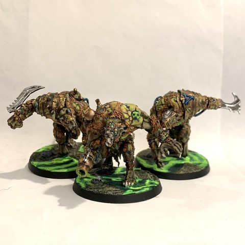 Three large rat-man-monsters in dark greens and browns. Their flesh is tearing away showing grotesque green-tinged skin and muscle. They have brass armor and weapons grafted to it. They walk over broken ground with green glowing waves in puddles. 