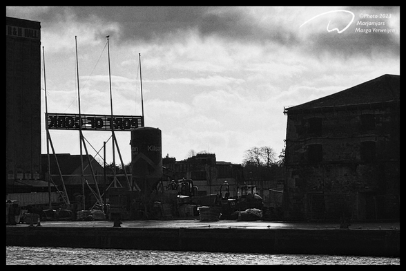 Early morning shot of Port of Cork with dark clouds above old warehouses.