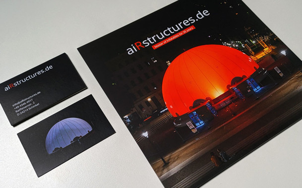 Photo of a square flyer and business cards for a client of mine, Airstructures. They do inflatable domes, that can be used for fulldome projection and can also be illuminated from the outside, so their corporate identity is very dark with a bit of colour. 