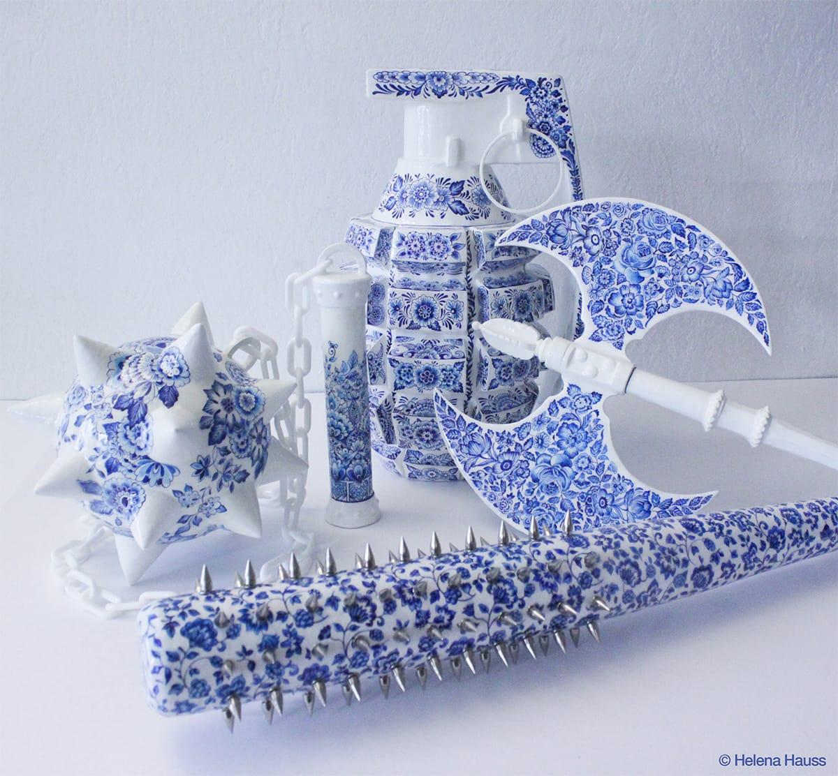 a collection of delft blue ceramic sculptures. objects include an axe, grenade, spiked bat, and flail