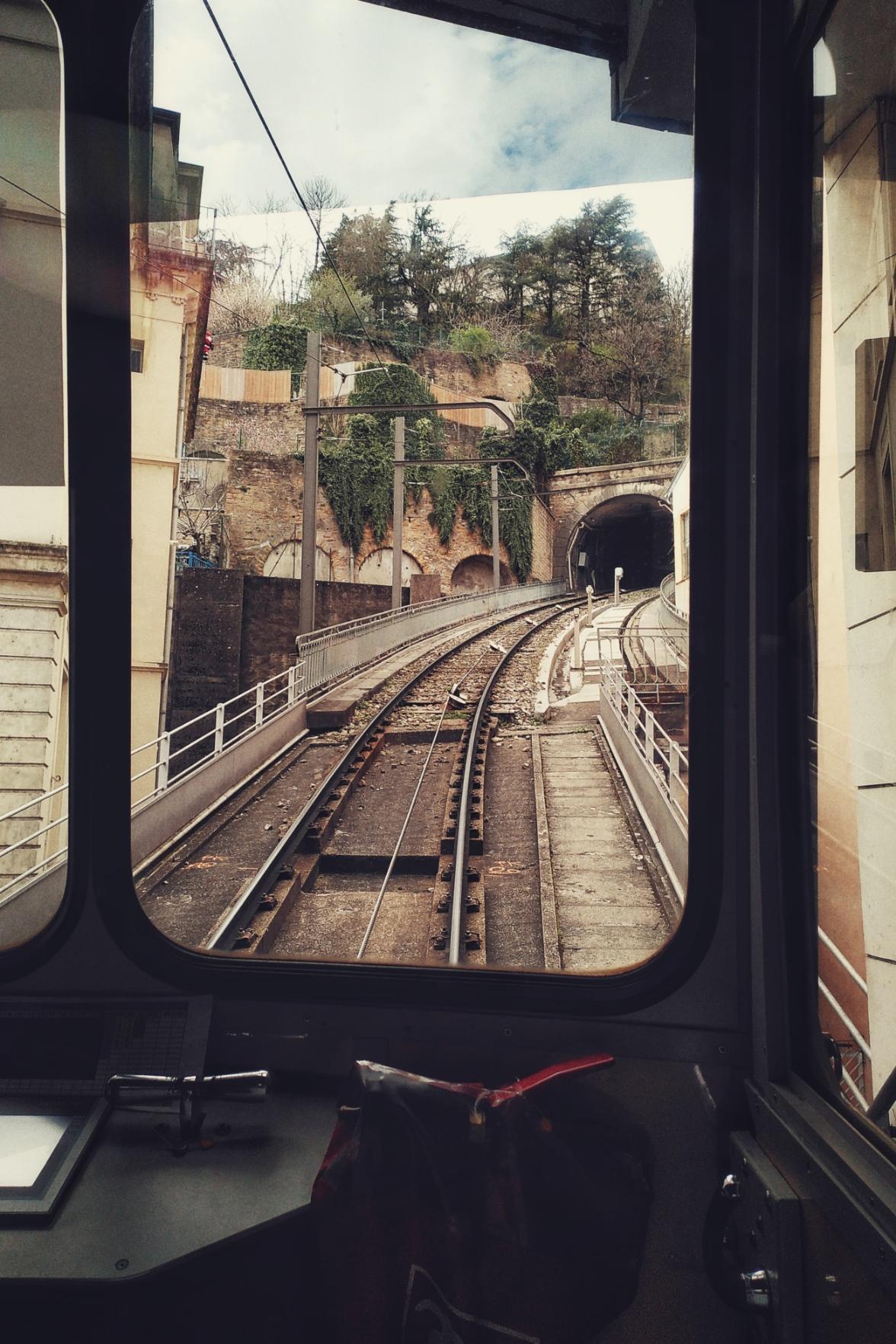A vertical colour photograph of a funicular railway line viewed through the glass of a train.