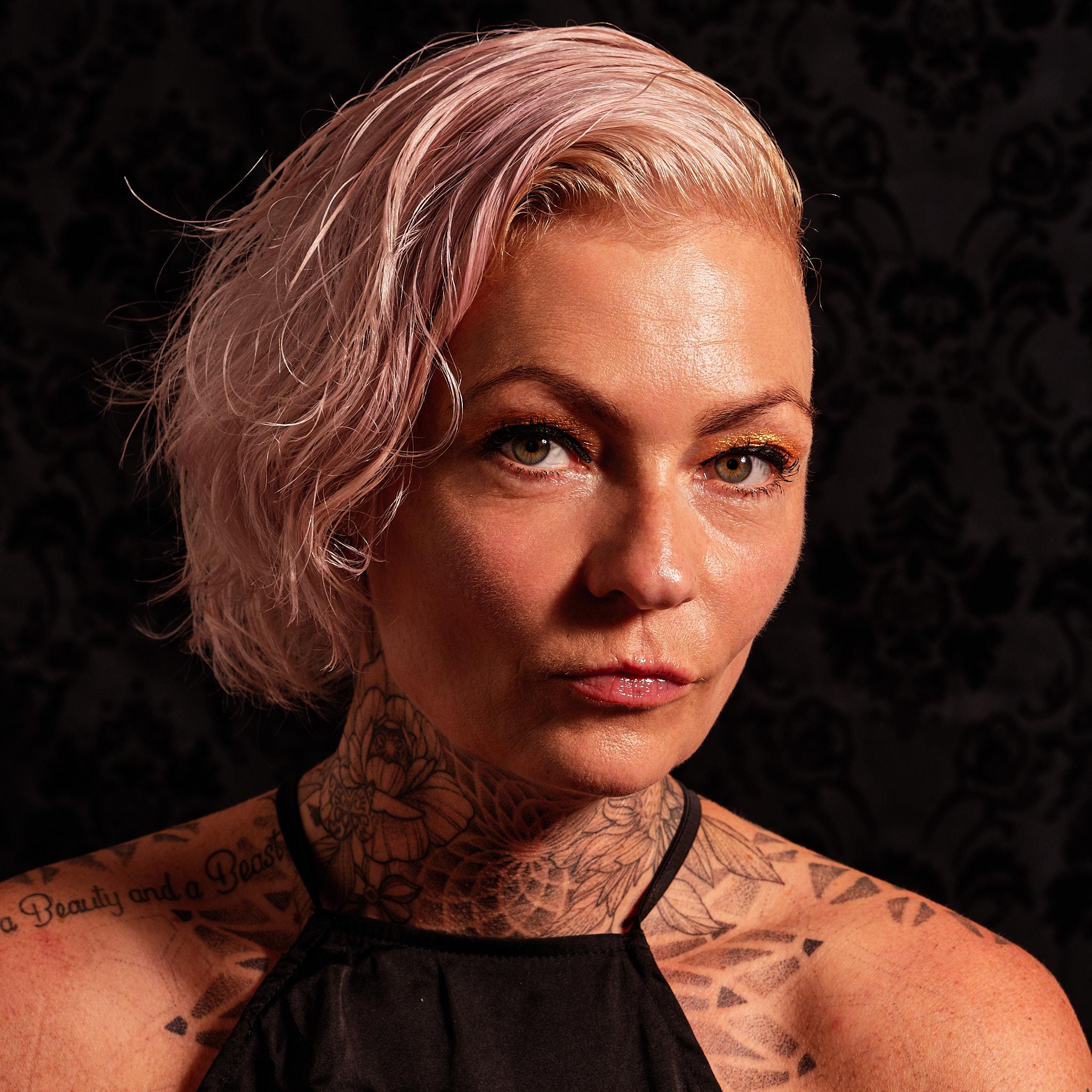 Pink haired woman looking into the camera.