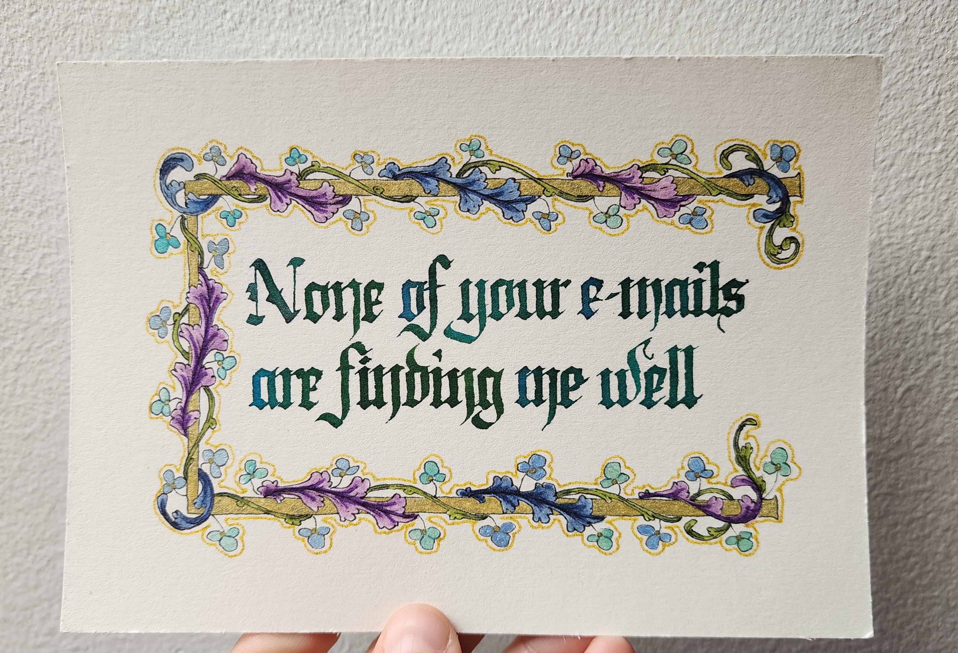 Calligraphed in blue-green sparkly ink in blackletter script and decorated with a border of blue, purple, and green vines and leaves swirling around a gold bar with metallic blue flowers, 'None of your emails are finding me well' Calligraphed in blue-green sparkly ink in blackletter script and decorated with a border of blue, purple, and green vines and leaves swirling around a gold bar with metallic blue flowers, 'None of your emails are finding me well'