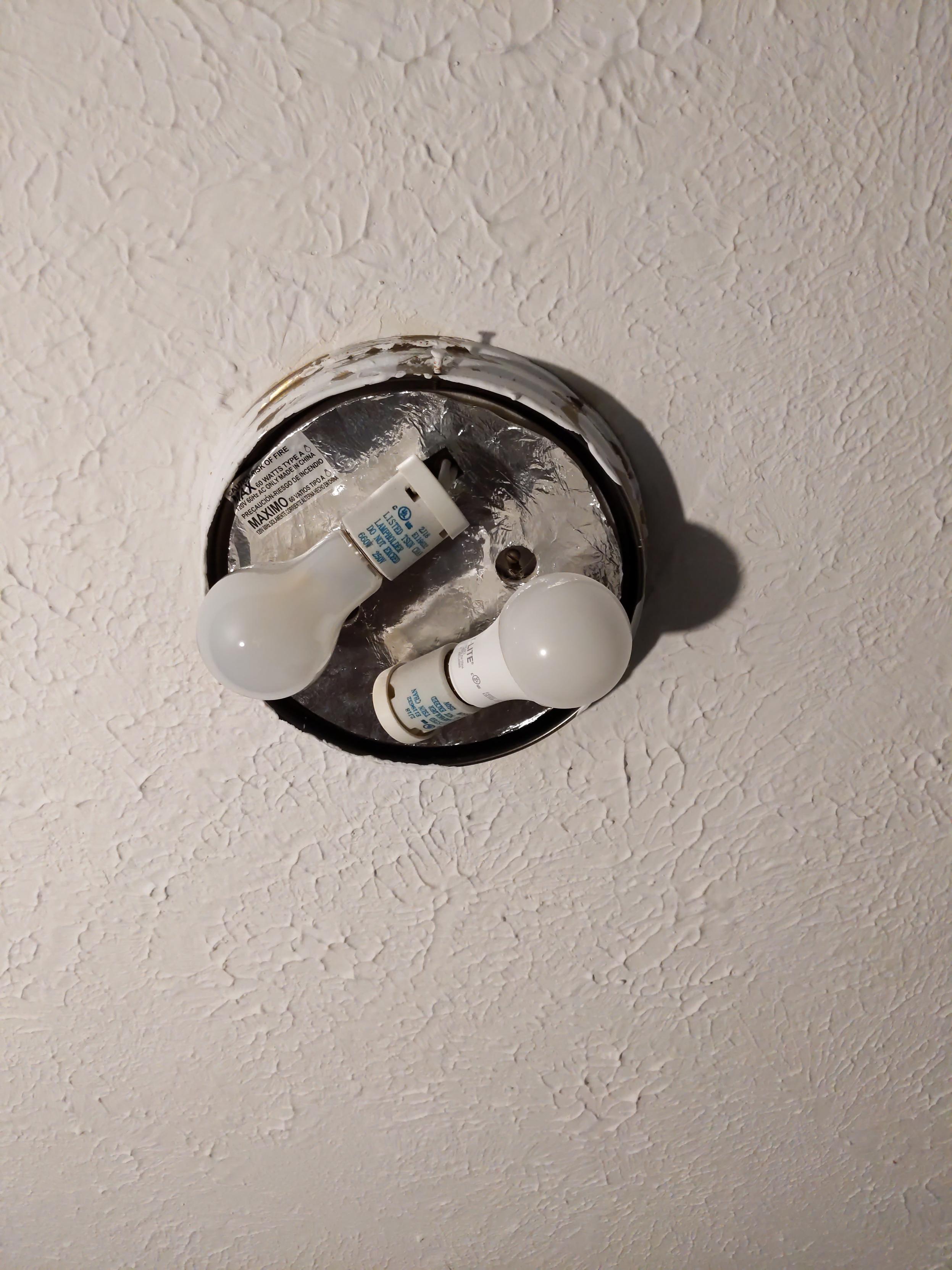 An exposed light fixture, covered in paint, which was used as a temporary light during the messy part of the library renovation.