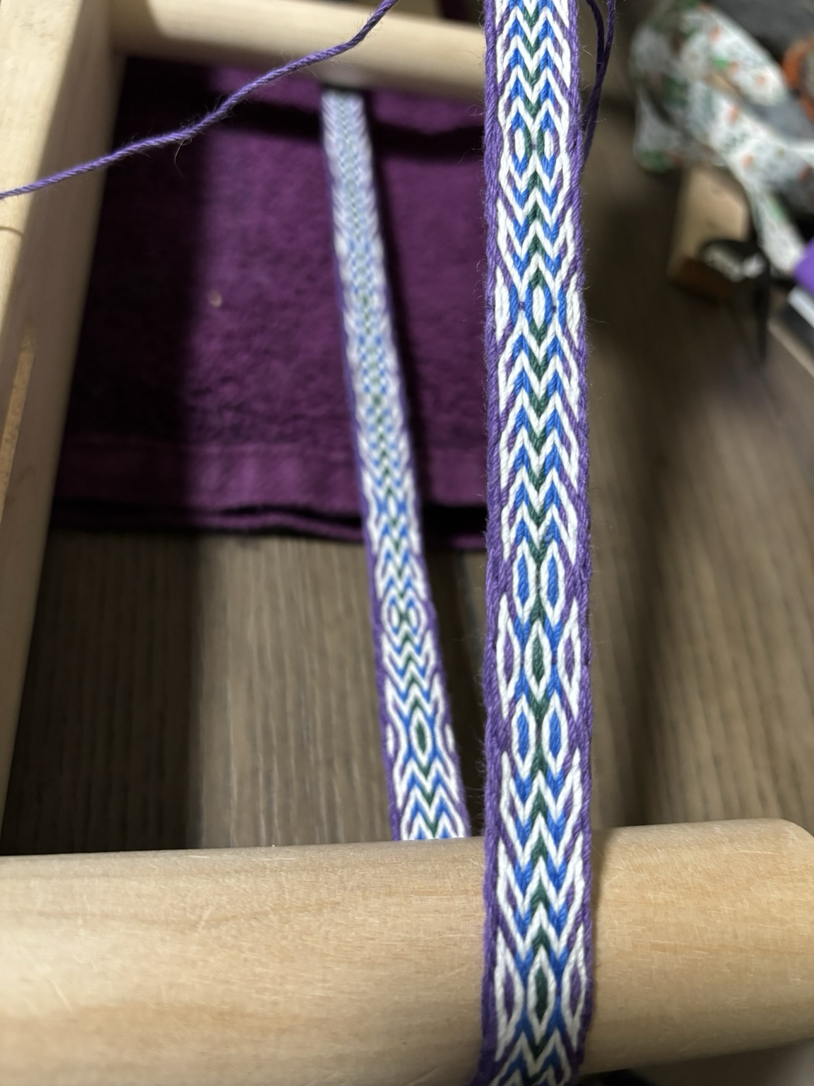 Purple-blue-green woven band with M and W shapes.