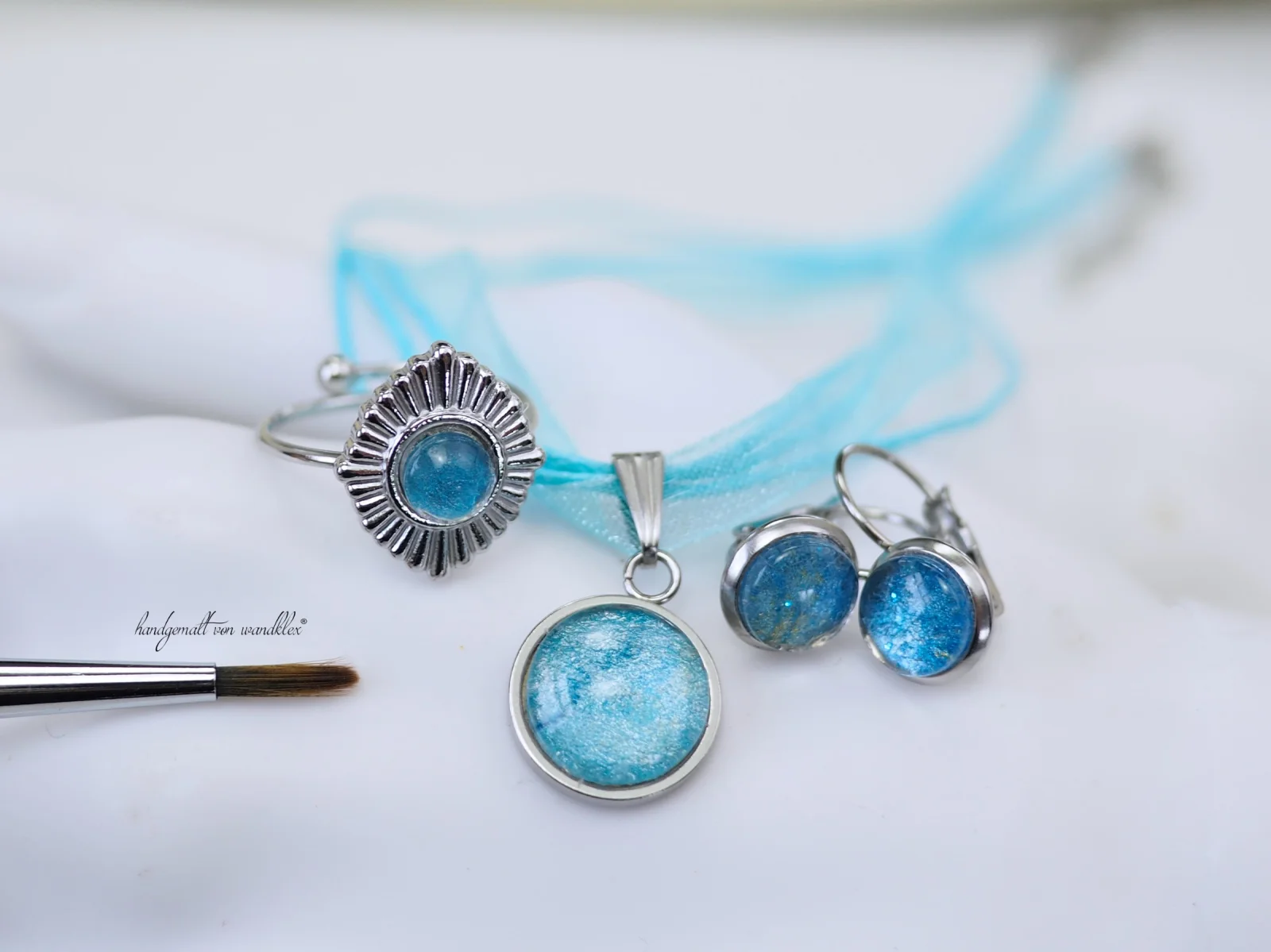 Halsschmuck 12mm-Galaxien Fassung  mit 45cm-Chiffon-Textilkette mit Metallverschluss, um 4cm verstellbar
Edelstahlring  6mm-Motiv mit rautenförmigem Ringblatt mit offener Schiene
 und passende zierliche Ohrhänger oder Ohrstecker mit 6-8mm-Galaxien