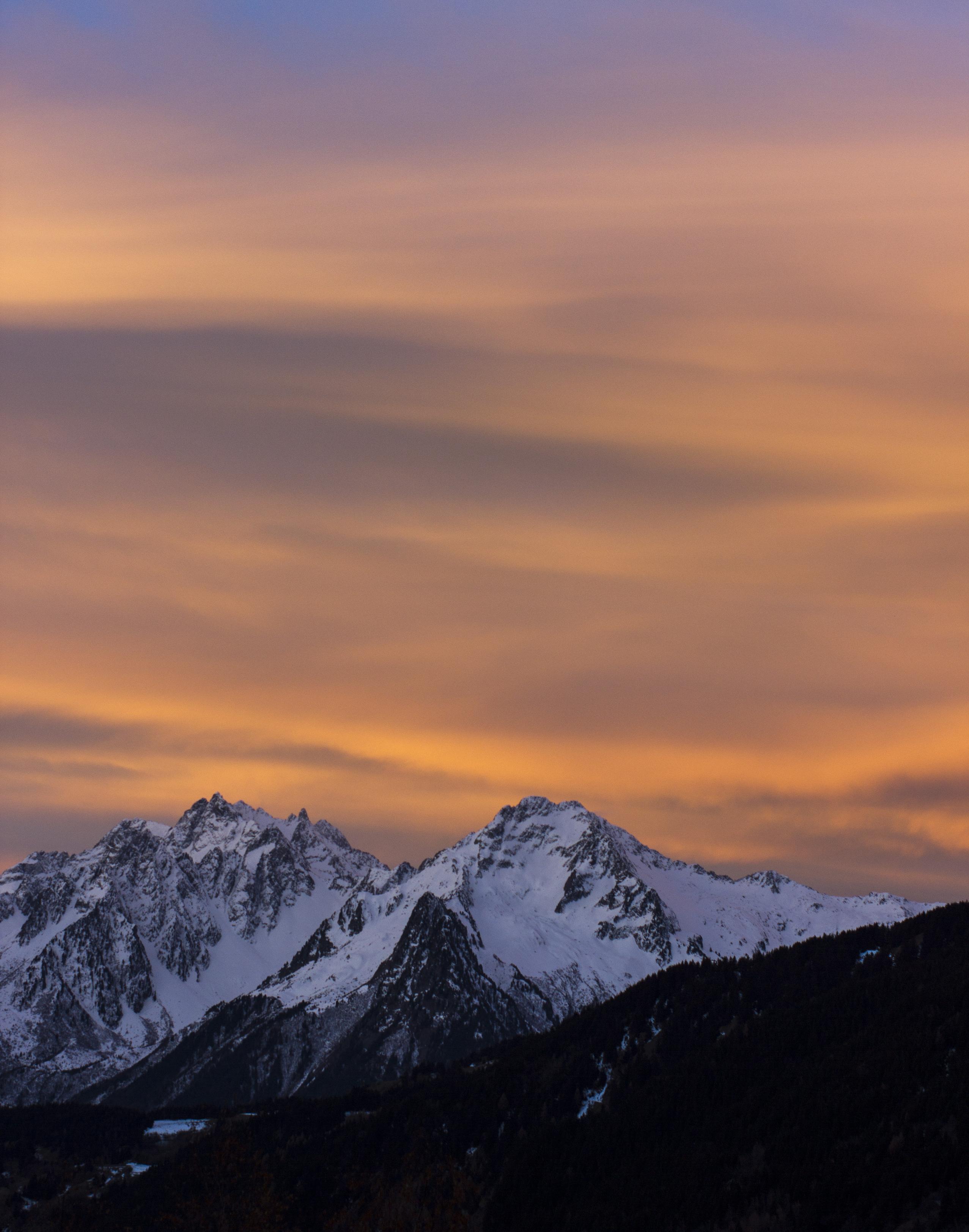 alps mountains after sunset, so we see the sun lensing and lighting the clouds from below