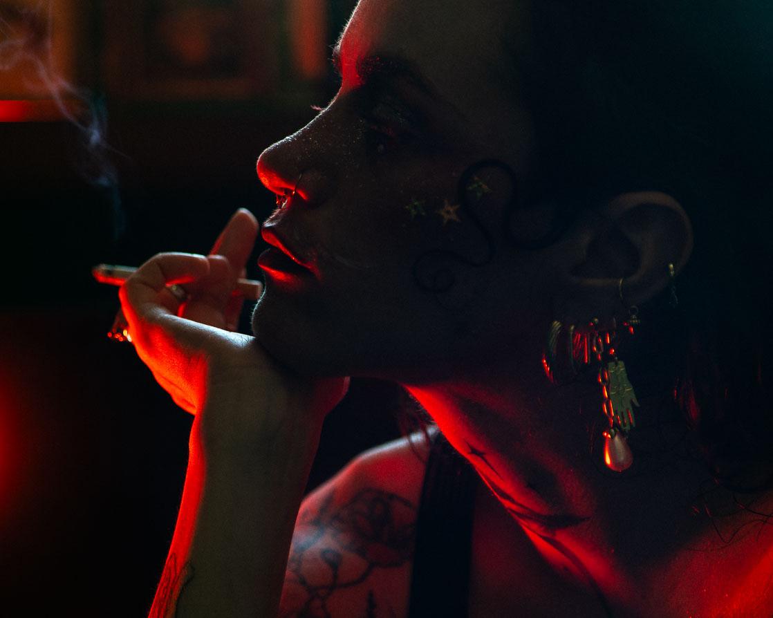 Visage pensif et mélancolique de profil dans une lumière sombre et rouge. 