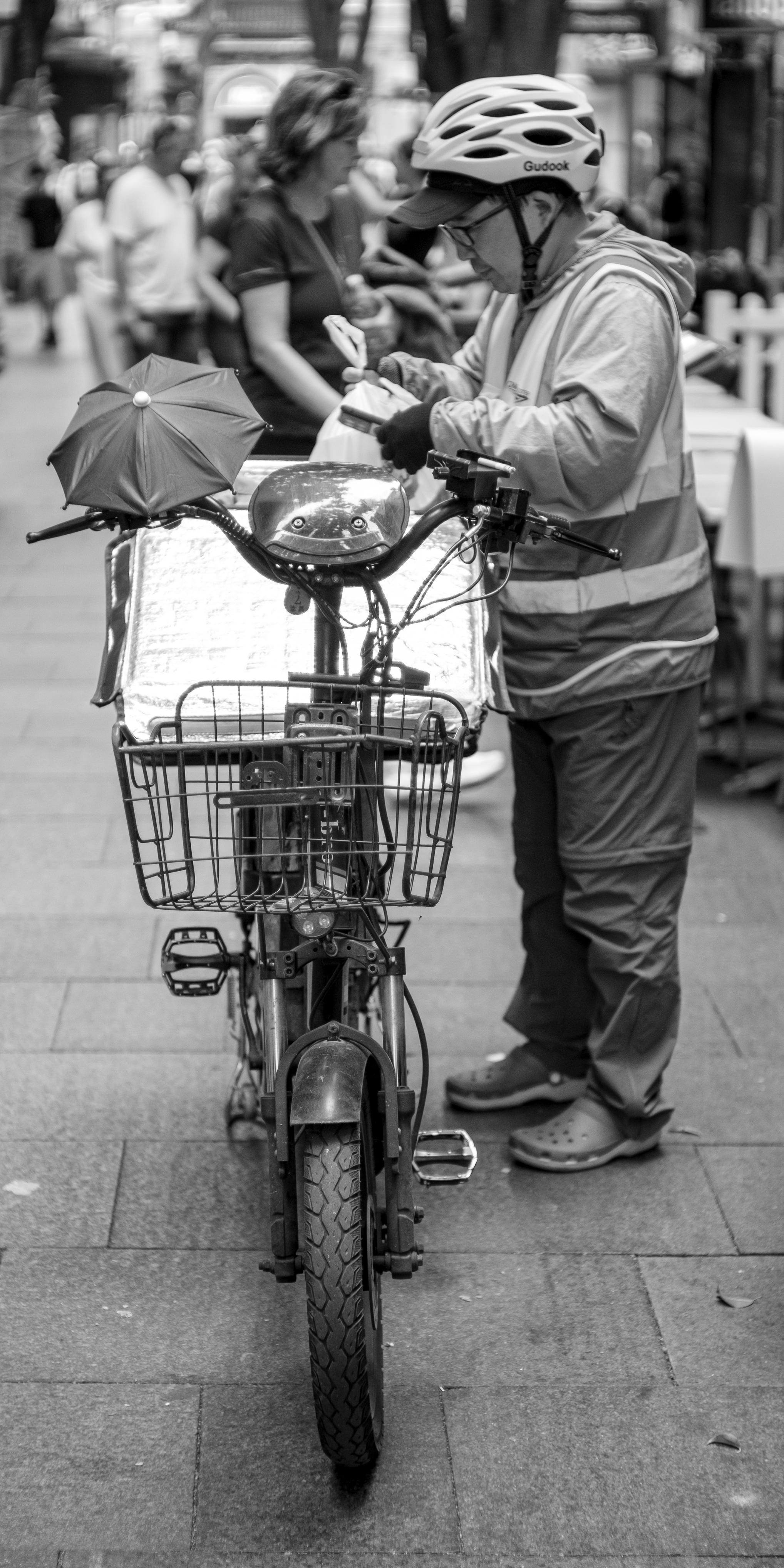 Black and white photo of a bicycle delivery person.