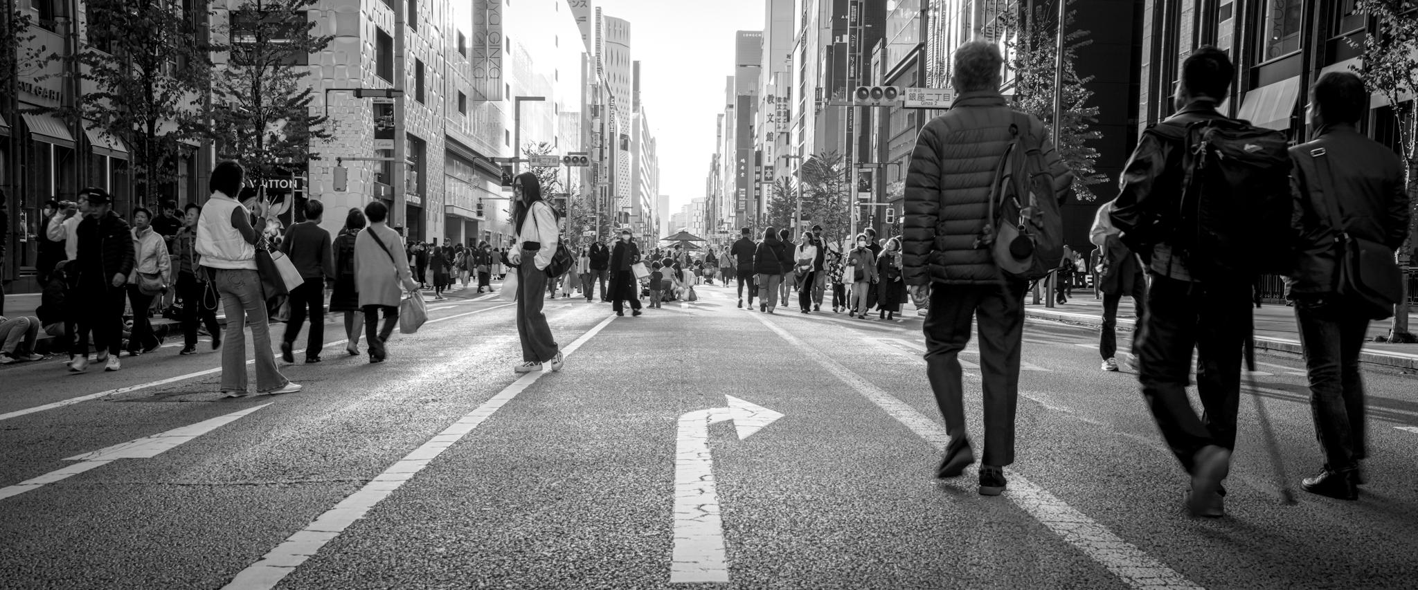 Black and white photo of people on the road in Ginza.