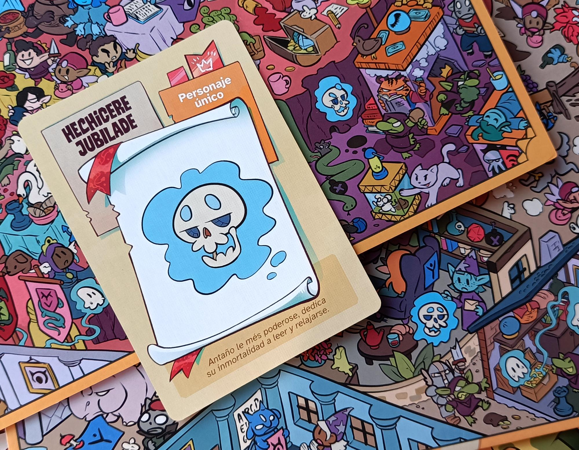 Una de las cartas del juego, la de le hechicere, apoyada sobre dos tableros donde podemos ver a le hechicere flotando por ahí