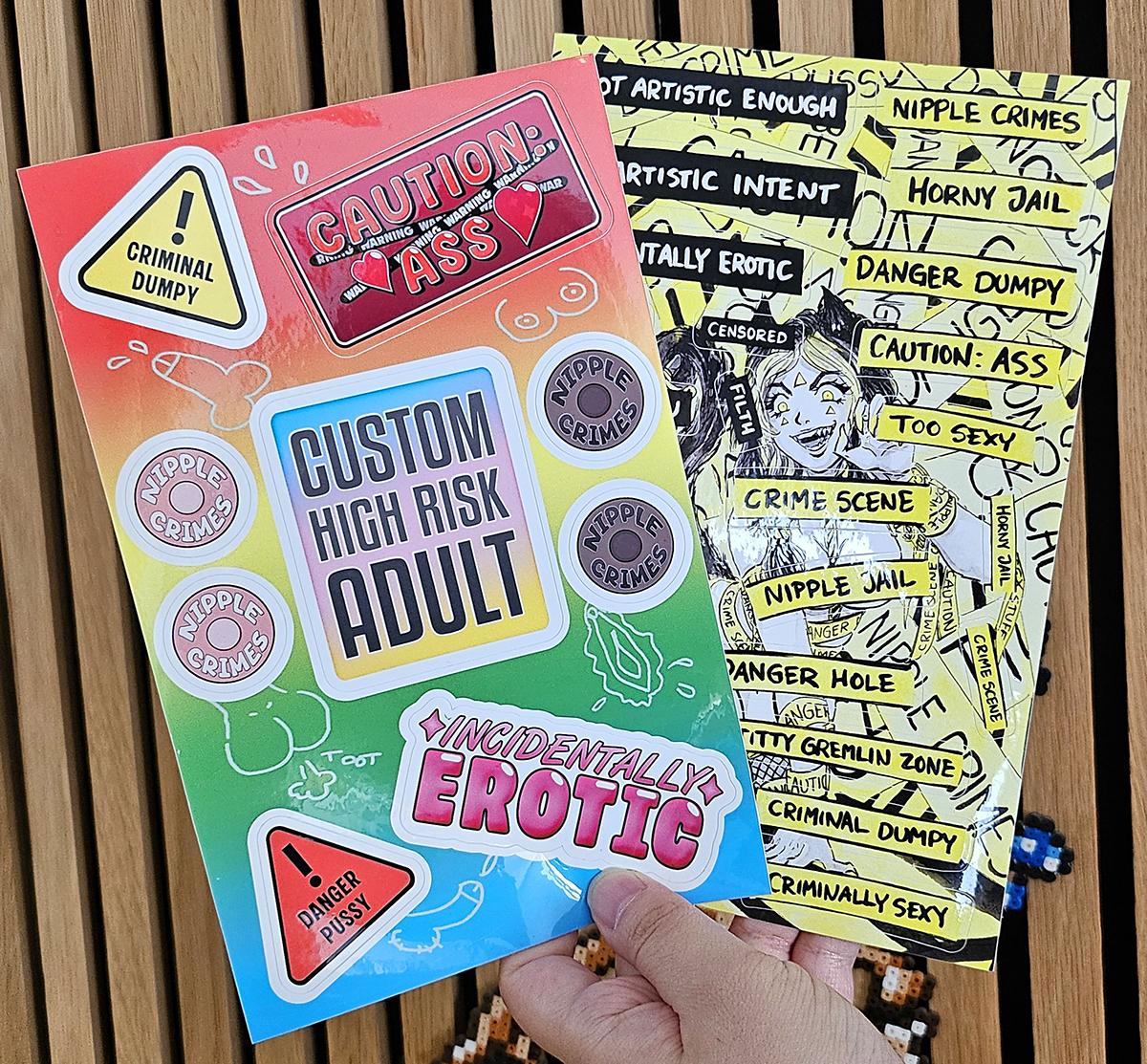 Jen's hand holding up two sticker sheets that show anti censorship art