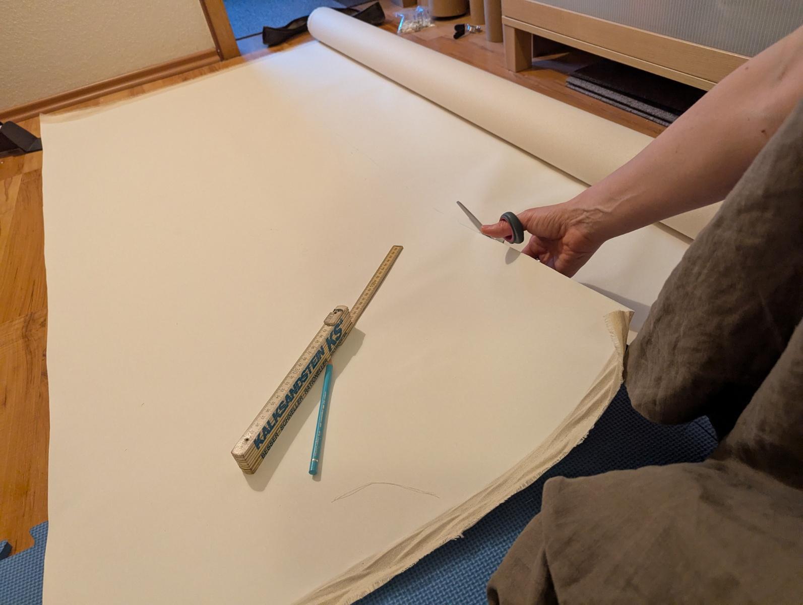 Me obediently cutting the rolled up canvas into squares, sitting on the floor. My tools (color pencil and ruler) are next to me.