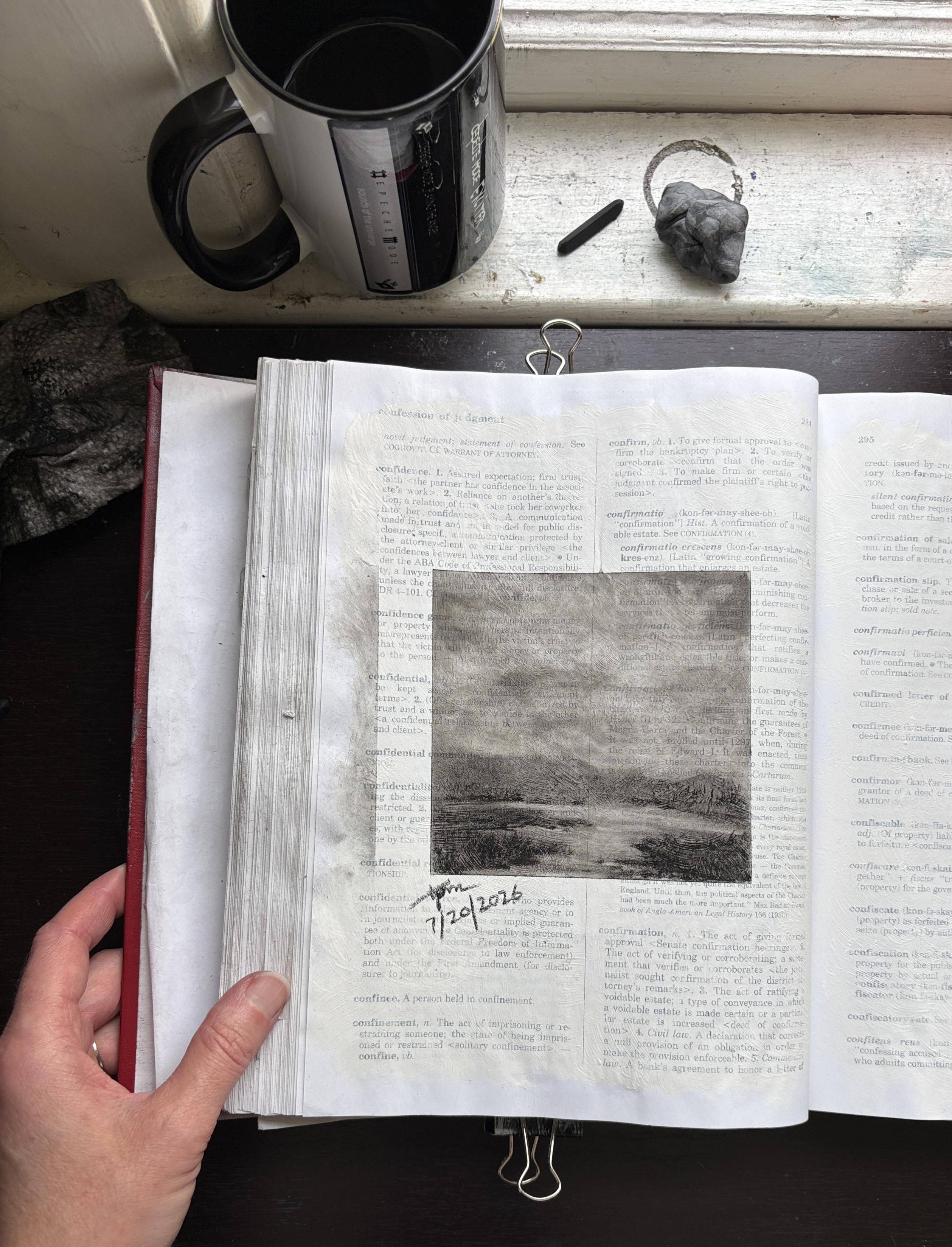 Page 294 in Tisha Mark’s law dictionary. My hand holds my law dictionary opened to a page with a charcoal sketch of a marshy landscape study. Words on the page are partially visible underneath a thin layer of gesso and the sketch. On the windowsill at the top of the photo is a coffee cup, piece of charcoal, and a kneadable eraser.
