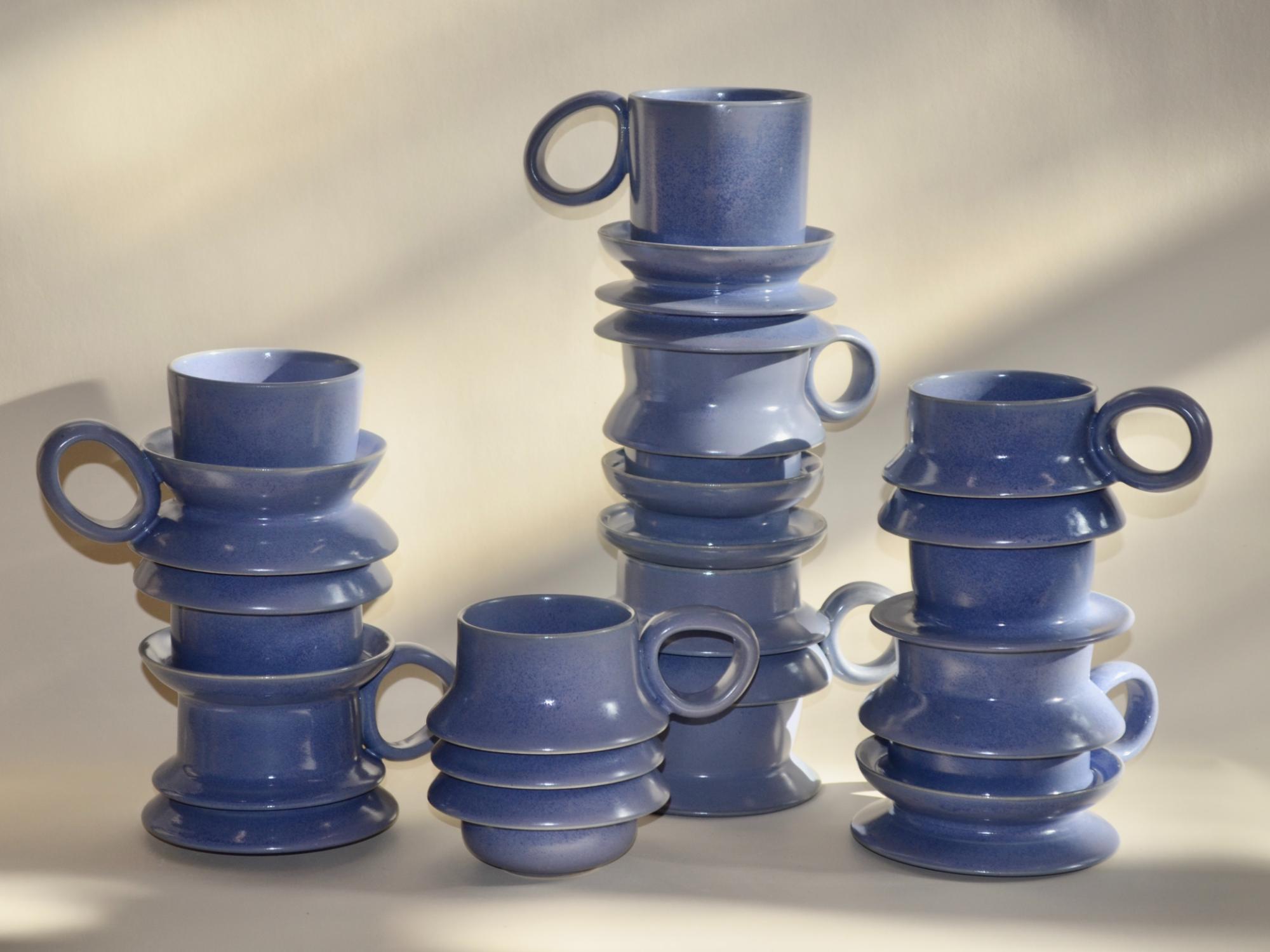 a collection of periwinkle mugs with ripples on their bodies