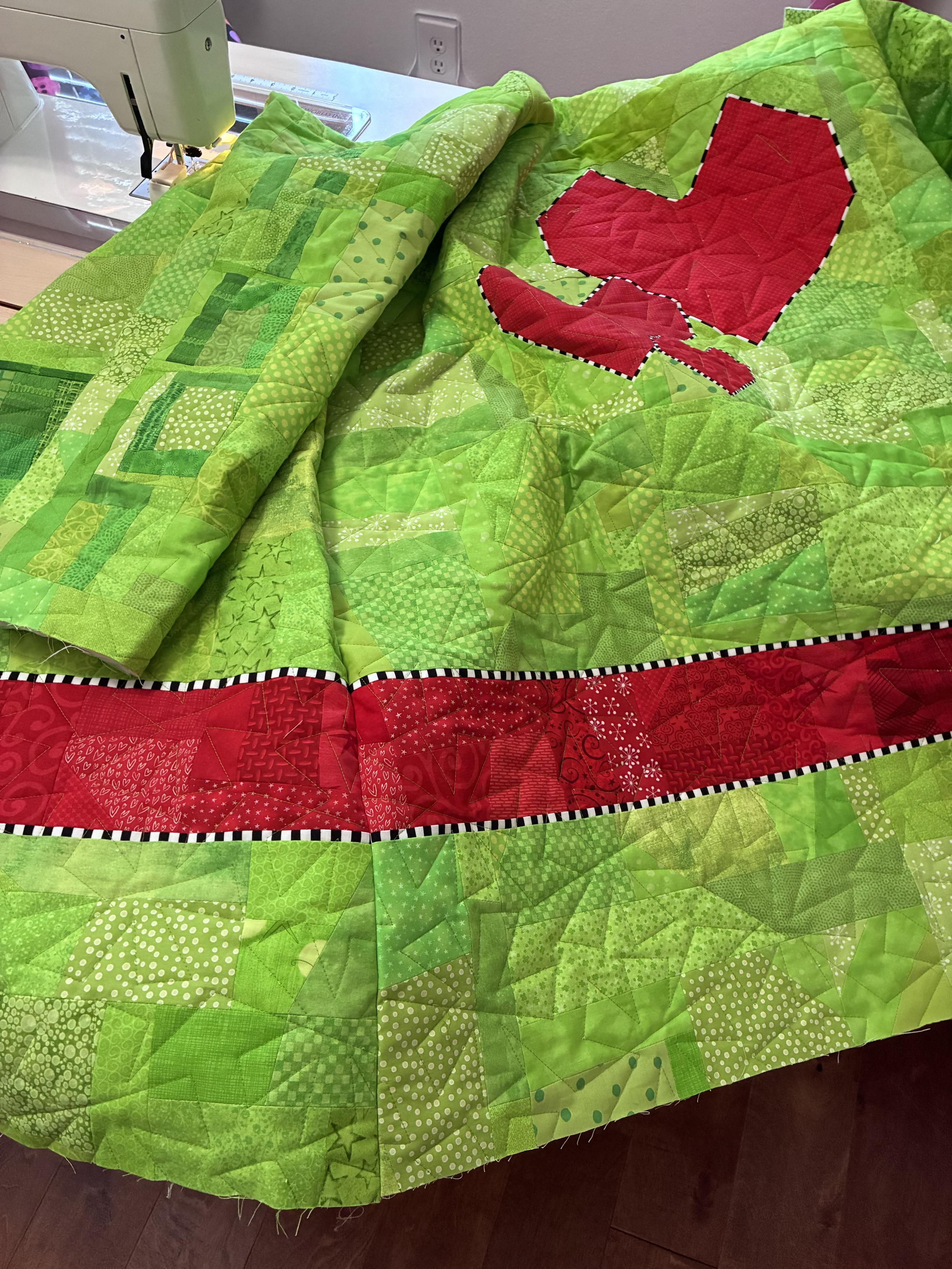Improv quilted lime green coat with 3 red hearts on the back spread out on a counter
