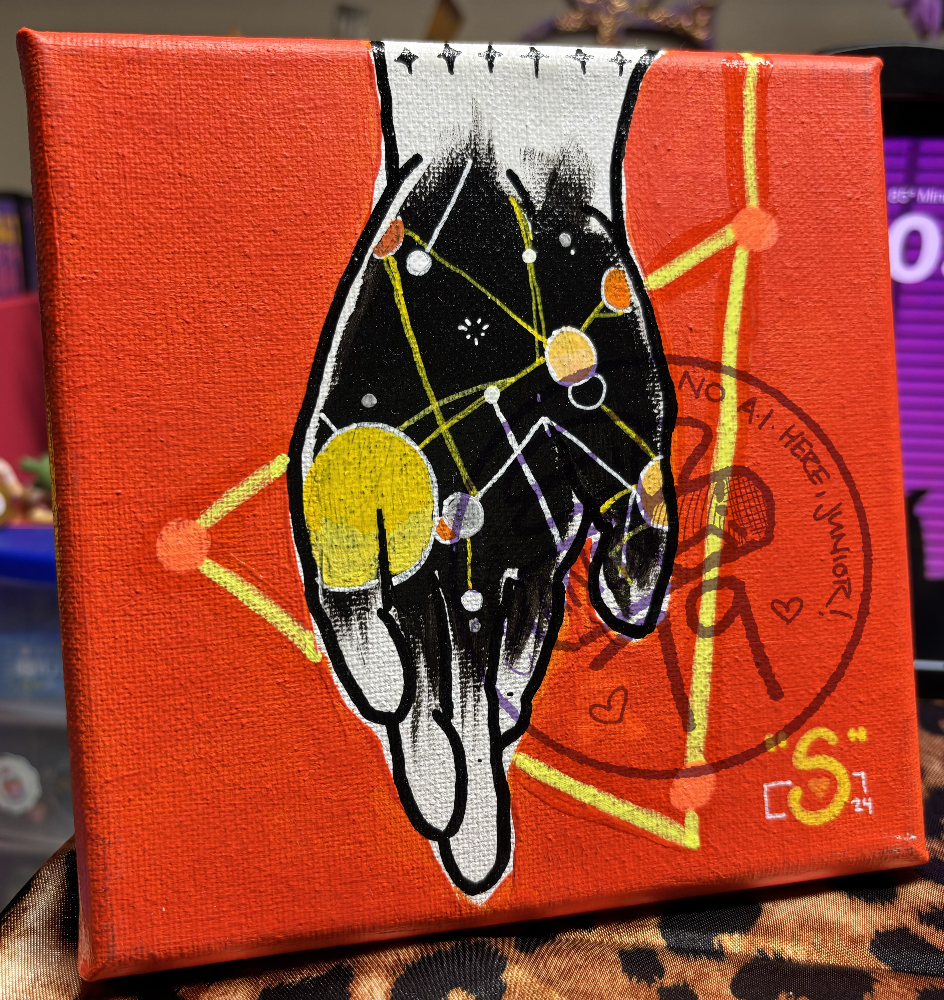 small orange painting of a white hand with its palm painted black. there's several small lines and circles painted on and around the hand, with a large yellow triangle surrounding the hand.