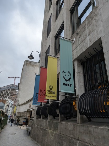 Colorful banners outside on the side of a building that say Wolf #streetfood