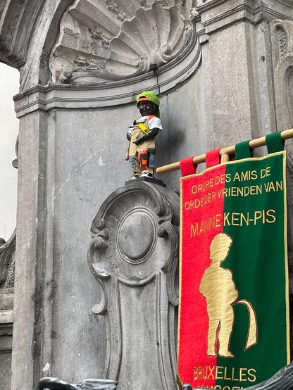 Manneken Pis statue in Brussels dressed as a repairer