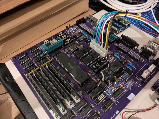Closeup photo of my Macintosh Plus clone board, with a ZIF socket installed  in place of the CAS PLD.
The board is screwed on a wood slab.