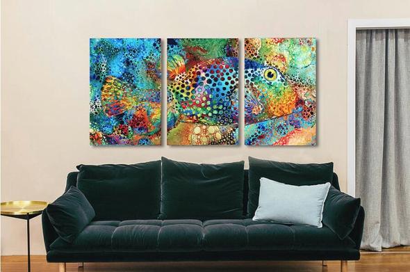 Large colorful puffer fish in three panels over a sofa by artist Sharon Cummings.