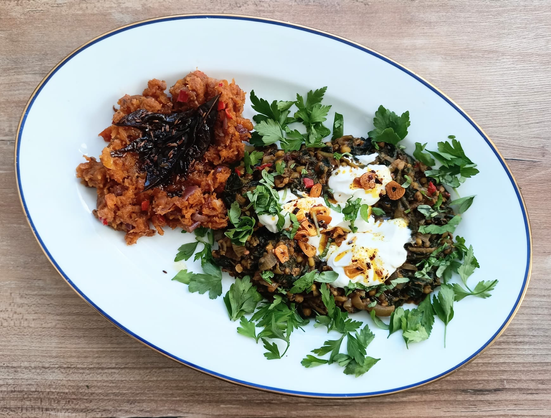 Auf einer Servierplatte der fertige Stampf mit gerösteten Curry-Blättern, daneben Mungobohnen mit Spinat, Joghurt und Petersilienblättern