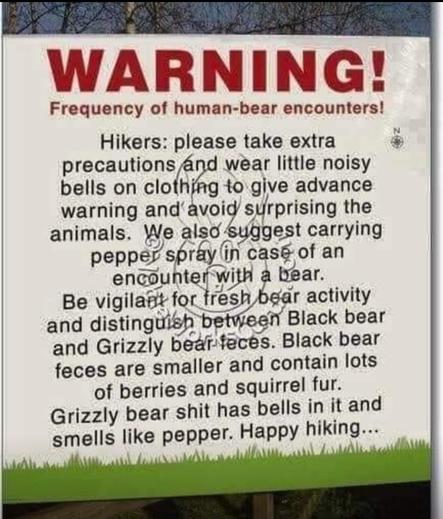 Park district sign, which reads:

 "WARNING!

Frequency of human-bear encounters!

Hikers: please take extra precautions and wear little noisy bells on clothing to give advance warning and avoid surprising the animals. We also suggest carrying pepper spray in case of an encounter with a bear.

Be vigilant for fresh bear activity and distinguish between Black bear and Grizzly bear feces. Black bear feces are smaller and contain lots of berries and squirrel fur.

Grizzly bear shit has bells in it and smells like pepper. Happy hiking...