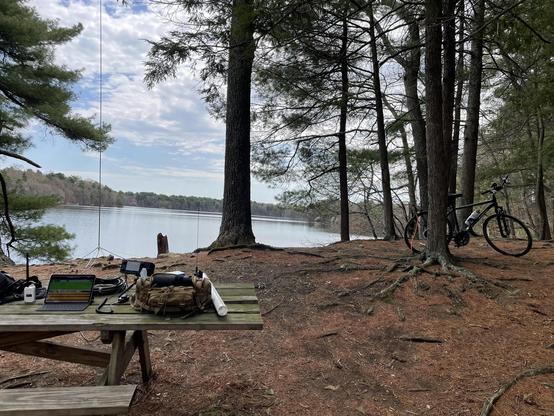 Picture of a lake with a bike and ham radio (amateur radio). The picture captures a task called POTA parks on the air, where the ham radio operator is performing FT8 on the 20 meter band. The task is to get at least 10 contacts to activate a park.