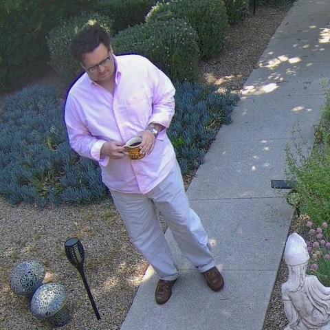 Kyle on the walkway with a coffee mug. You know what's in that mug? Hot, tasty, stimulating black coffee is in that mug.