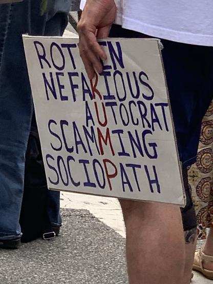Philly May Day rally sign: Rotten Nefarious Autocrat Scamming Sociopath