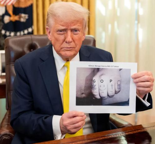 Trump holding up a picture of some hand tattoos that almost certainly wasn't altered to add the letters GOP.