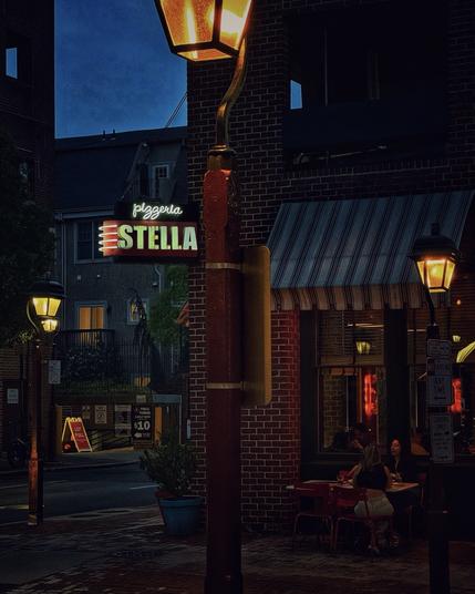 A pizzeria at a street corner at dusk
