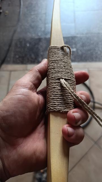 Zwischenversuch an einem Primitivbogen eine Wicklung für das Griffstück anzufertigen.
Das lose Fadenende wird mittels einer Extra eingewickelten Schlaufe, nach innen gezogen