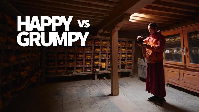 Thumbnail for the video. Tashi inside the temple taking photos as a shaft of light illuminates the scene.