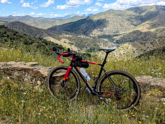 My bicycle standing against the guardrail with mountains in the background.
