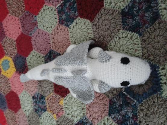 Une peluche dragon blanc et gris au crochet.