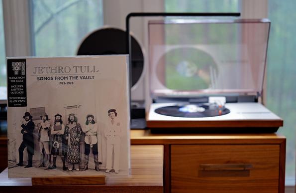 Jethro Tull - Songs from the Vault (1975-1978) - RSD25 LP cover.

On a white background, against a wall, a black and white photo of the various members of Jethro Tull from this period, dressed in various garb.

The black LP plays on a vintage, restored Bang & Olufsen Beogram 4000 linear-tracking turntable to the right.