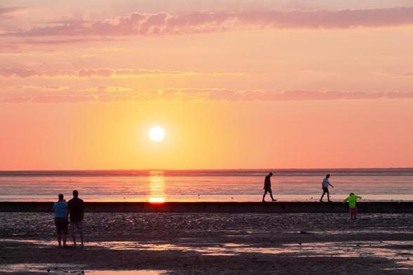 People walking at the beach in sunset