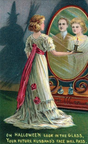 A woman on Halloween sees her future husband in a mirror. An image from an early 20th-century Halloween greeting card.