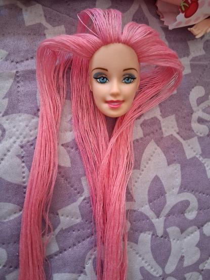 La muñeca en proceso de reroot, con la cabeza quitada y el cabello a medio poner
