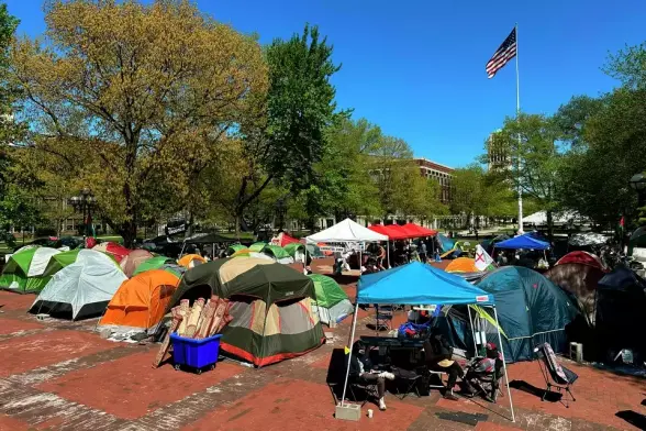 Protest encampment on campus with tents.