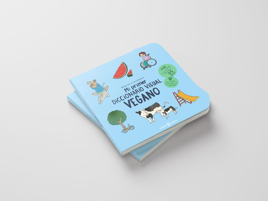 Foto del libro "Mi primer diccionario visual vegano", de Escoleta Vegana. En concreto, foto de dos ejemplares apilados, aparece la portada, que contiene el título y algunos dibujos pequeños alrededor: una rodaja de sandía, una vaca con su hija, un tobogán, un árbol y una bici, une niñe en silla de ruedas, otre niñe estirando junto a su gata.