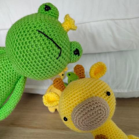 Along with the tall giraffe, a tall frog with a yellow crown and an annoyed face pops up in front of the small giraffe and frog.