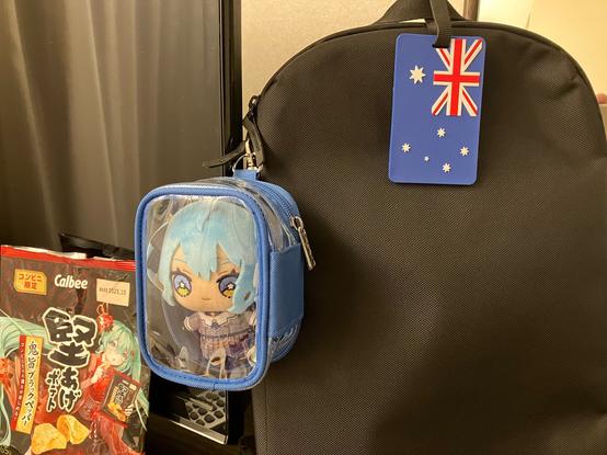 Suisei in her new bag on my bag! An inexplicable bag of Miku crisps are in the background.