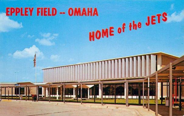 The arrival side of the terminal is seen under bright blue skies. Above in text it says the name of the airport and Home of the Jets.