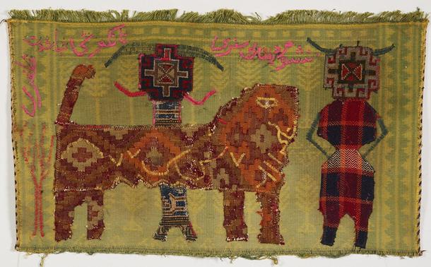 Woven and sewn textile with a green and yellow patterned field depicting two abstract patterned figures wearing horned headdresses and an orange feline creature with a diamond pattern.