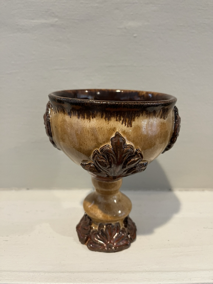 A quarter turned view shows the articulated leaves that alternate with the lions heads around the belly of the vessel. These are also glazed in Copper Float
